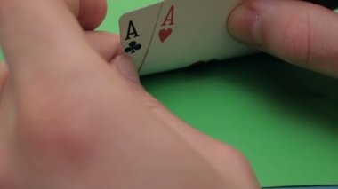 Profesyonel bir poker oyuncusunun elinde iki as. Poker oyuncusu bahsi artırmadan önce kartlarını kontrol eder. Profesyonel poker oyuncusunun iki ası vardır. Kumar anlayışı. Profesyonel.