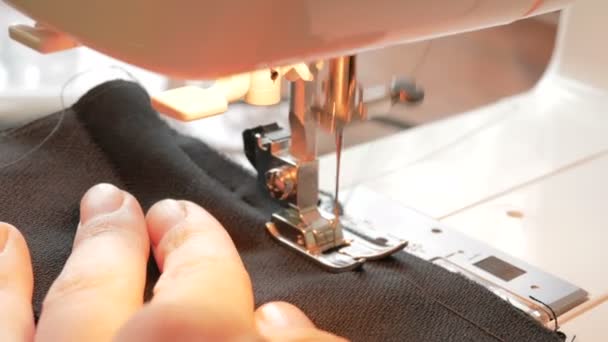 Primer plano de una máquina de coser en la que el diseñador de moda cose los detalles de un nuevo vestido.Joven ama de casa que cuida de coser un vestido con una máquina de coser. Primer plano de las manos de una joven atractiva — Vídeos de Stock