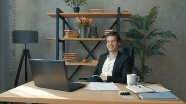 Een jonge aantrekkelijke zakenman onderhandelt met een belangrijke klant via videoverbinding. Een jonge knappe ceo leidt een ontmoeting met ondergeschikten via videolink. — Stockvideo