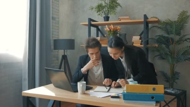 Les partenaires commerciaux se réjouissent d'un accord réussi au bureau de leur entreprise. Les employés de bureau développent un concept pour une nouvelle marque dans leur bureau. Un jeune PDG avec son partenaire commercial est en train de résoudre — Video