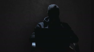 Siyah kapüşonlu bir bilgisayar korsanı şifreleri kırıp önemli internet kullanıcı veritabanlarını indiriyor. Siyah kar maskeli bir internet korsanı sandalyeye oturur ve laptoptan veri çalar. Şey...