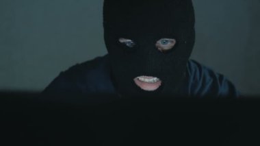 Siyah kar maskeli bir internet korsanı sandalyeye oturur ve laptoptan veri çalar. Siyah kapüşonlu bir hacker kurbanını telefonla arıyor ve veritabanının şifrelerini kırmakla tehdit ediyor.