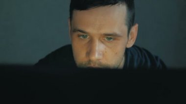 Genç bir bilişim uzmanı dizüstü bilgisayarı üzerinde çalışıyor. Genç ve çekici bir adam dizüstü bilgisayarı üzerinde çalışıyor. Genç programcı bilgisayarında yeni bir uygulama için kod yaratıyor. Gelecek vaat eden genç bir programcı...