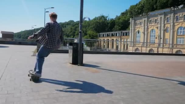 O skatista profissional executa truques para melhorar suas habilidades. Um cara jovem faz um kickflip enquanto monta um skateboard.Young cara atraente está montando um skate. Um skatista profissional — Vídeo de Stock