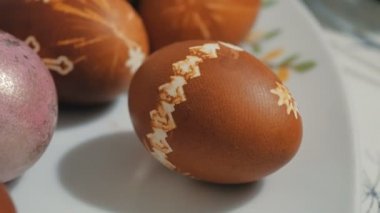Çok renkli Paskalya yumurtaları bayram masasının üzerinde. Güzel dekore edilmiş Paskalya yumurtaları tabakta yatıyor..