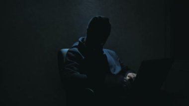 Siyah kar maskesi takan bir siber terörist bir web sitesini hackliyor ve internet kullanıcılarından önemli verileri çalıyor. Siyah kar maskeli bir internet korsanı sandalyeye oturur ve laptoptan veri çalar.