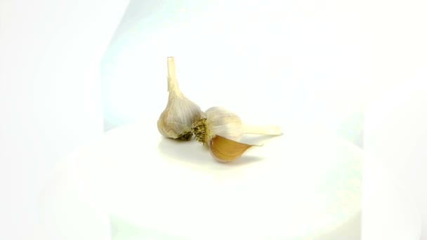 Close-up Fresh head of garlic rotates on a white background.Fresh juicy organic garlic rotates on a white plate.Healthy food concept. — Stock Video