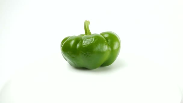 Φρέσκες ζουμερές πράσινες πιπεριές εναλλάσσονται σε λευκό φόντο. Κοντινό πλάνο Φρέσκο πράσινο βουλγαρικό πιπέρι περιστρέφεται σε λευκό φόντο. — Αρχείο Βίντεο