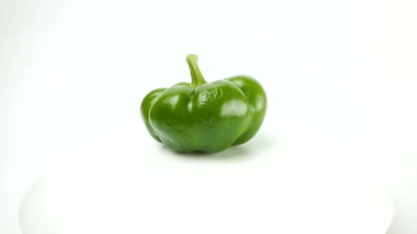 Φρέσκες ζουμερές πράσινες πιπεριές εναλλάσσονται σε λευκό φόντο. — Αρχείο Βίντεο