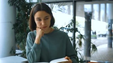 Genç, neşeli bir kız öğrencinin yakın plan portresi, kitaptaki gerekli bilgileri arıyor, derse hazırlanıyor. Genç ve çekici bayan öğrenci bir kitap okuyor ve düşünüyor.