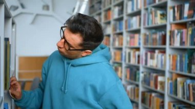 Gözlüklü genç bir milenyum öğrencisi bir halk kütüphanesindeki kitaplıklardan ilginç bir kitap seçer. Gözlüklü genç bir öğrenci sınava hazırlanmak için gerekli ders kitabını arıyor.