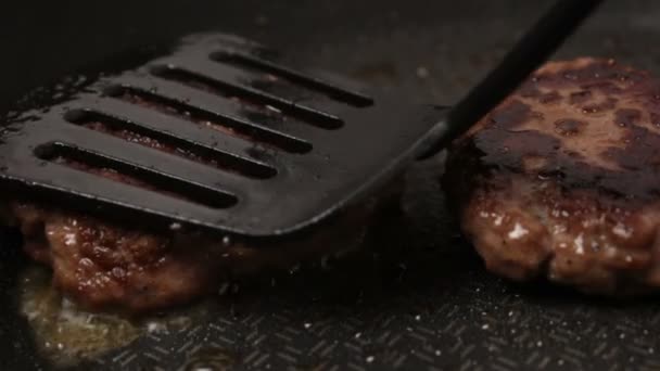 シェフはグリルに牛肉のパテを置きます。ジューシーな牛カツ,鍋で揚げ.グリルでハンバーガーのための牛肉カツのクローズアップ. — ストック動画