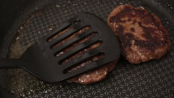 Uno chef mette le polpette di manzo sulla griglia. Una cotoletta di manzo succosa, fritta in padella. Primo piano di cotoletta di manzo per un hamburger sulla griglia. — Video Stock