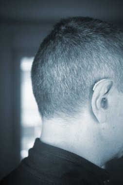 Modern dijital işitme cihazı orta yaşlı 50 'li yaşlarda bir adamın kulağında