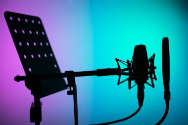 Voiceover studio large diaphragm cardioid microphone, headphones and lectern in professional voice recording studios. clipart