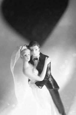 Düğün çifti pasta üstte plastik figürler smokin gece elbisesi, beyaz gelinlik peçesi.