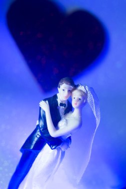 Düğün çifti pasta üstte plastik figürler smokin gece elbisesi, beyaz gelinlik peçesi.