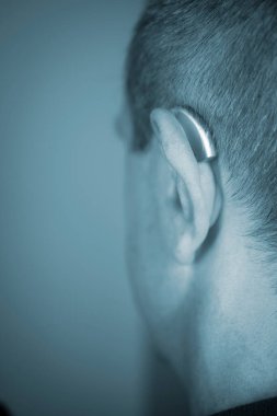 Modern dijital işitme cihazı orta yaşlı 50 'li yaşlarda bir adamın kulağında