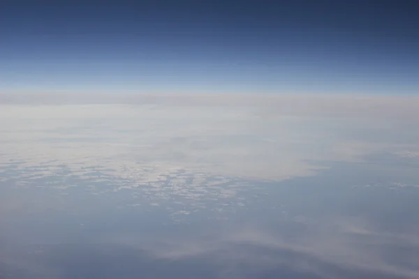 Céu azul com nuvens vistas da janela plana — Fotografia de Stock