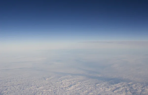 Céu azul com nuvens vistas da janela plana — Fotografia de Stock