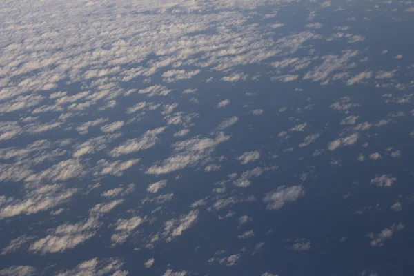 Céu azul com nuvens vistas da janela plana — Fotografia de Stock