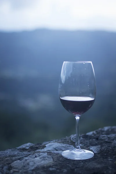 Kristallglas rödvin på stenmuren med himmel — Stockfoto