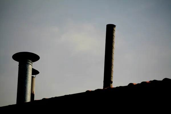 建物の屋根の上の煙突鍋と青空 — ストック写真