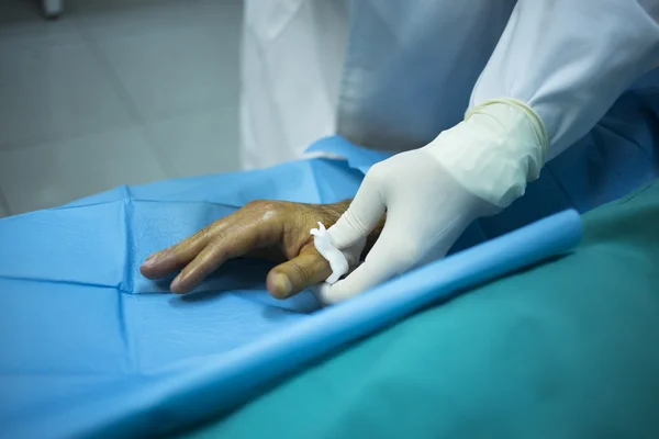 หมอผ่าตัดฉีดคนไข้ในคลินิกโรงพยาบาล — ภาพถ่ายสต็อก