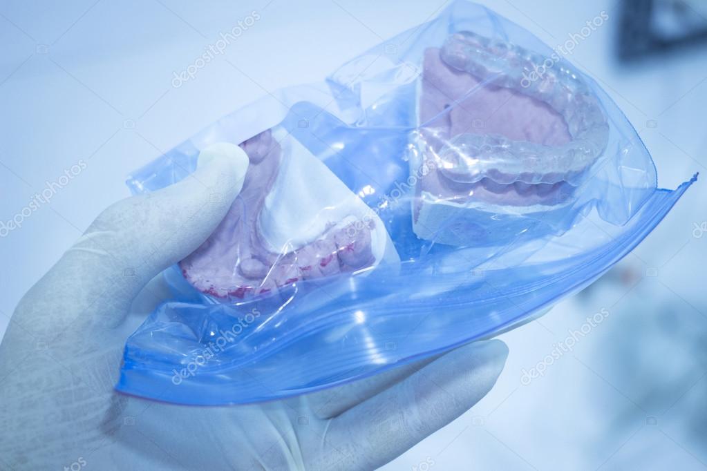 Dental mold dentist clay teeth plate ceramic colored cast model showing  tooth decay and gums of patient in dental clinic surgery for diagnosis and  treatment held in sterile glove hand of dentist