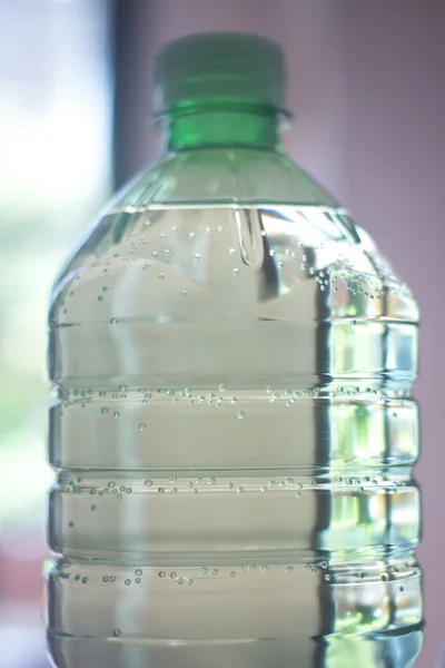 Bottiglia di acqua di plastica in luce finestra — Foto Stock