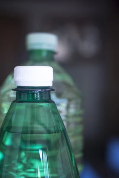 Bottiglie di acqua di plastica in luce finestra — Foto Stock