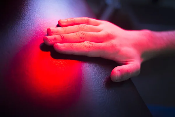 Patientenhand in roter Physiotherapie-Wärmebehandlung — Stockfoto
