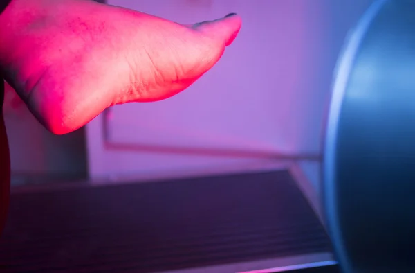 Patiënt voet in rode fysiotherapie warmtebehandeling — Stockfoto