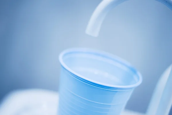 Zubař vodou opláchněte pohár klepnutím výplň v zubní klinice — Stock fotografie