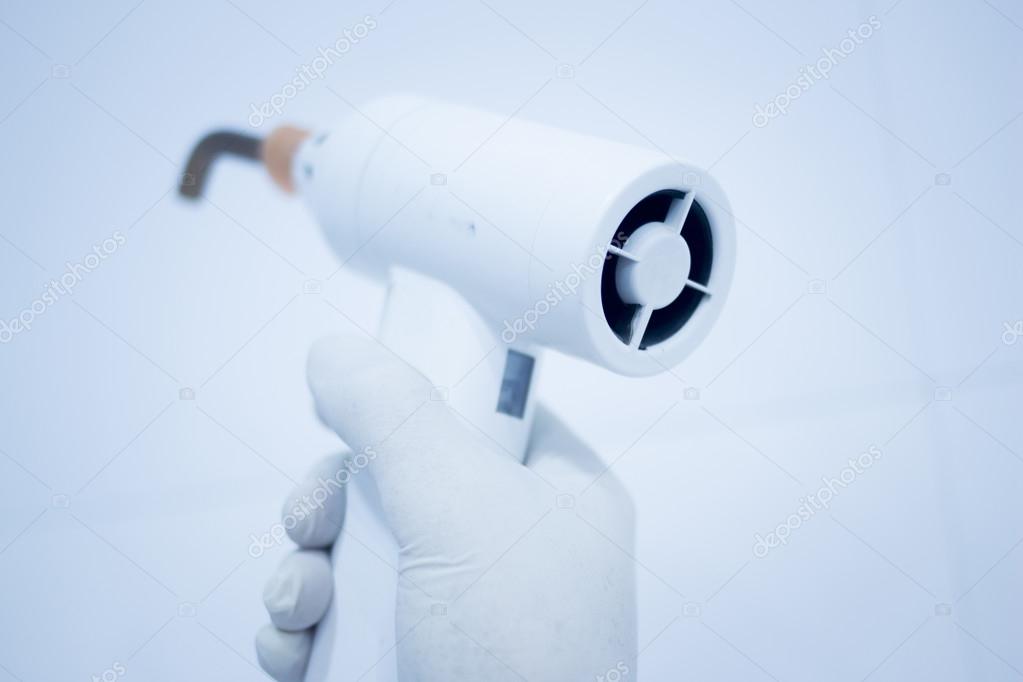 Dental filling gun in dentist hand in clinic office — Stock Photo