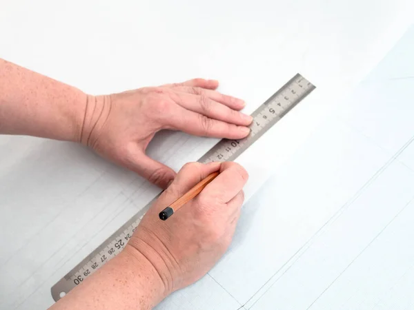 Copying pattern layout of dress with pencil and ruler on tracing-paper from graph paper at home — Stock Image Copying Pattern Layout Dress Pencil Ruler Tracing Paper Graph Paper Royalty Free Stock Images