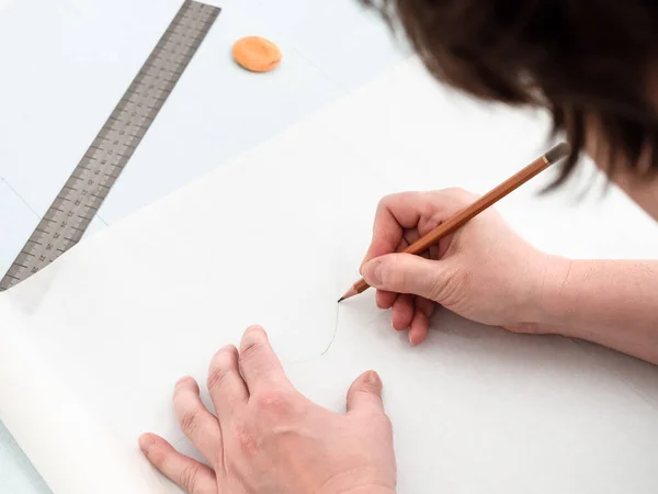 Tailor copies pattern layout of dress with pencil and ruler on tracing-paper from graph paper at home — Stock Image Tailor Copies Pattern Layout Dress Pencil Ruler Tracing Paper Graph Stock Photo