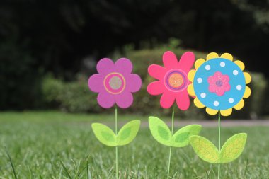 renkli çiçek yeşil yaprakları ile bir bahçe yeşil çim hazır. Londra Birleşik Krallık'ta bir ev arka bahçede üç güzel benzersiz yapay çiçek