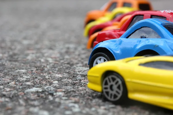 Auto colorate in miniatura in fila sul concetto di vendita su strada. Diverse auto colorate - blu, giallo, arancione, bianco e rosso auto a colori in piedi accanto - concetto di vendita agente auto — Foto Stock