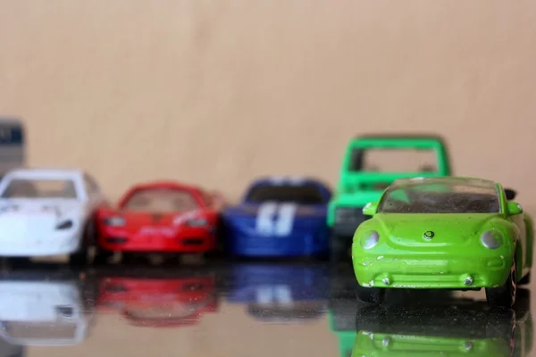 Verschillende miniatuur kleurrijke (blauwe, rode, groene, zwarte, witte) auto's permanent in lijn showroom auto agent verkoop concept — Stockfoto