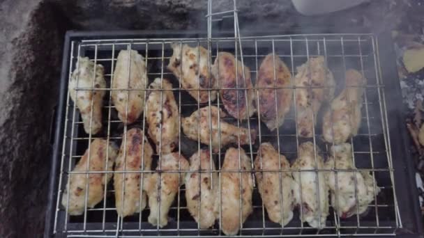 Process för att förbereda kyckling vingar på Black Metal grill. Rök från eld. — Stockvideo