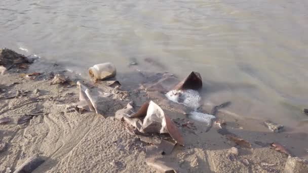 Un montón de residuos de plástico, placas, botellas rotas estériles fragmentos de latas de metal en la orilla — Vídeos de Stock