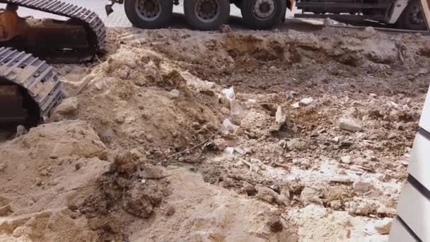 Road repair work. excavator metal bucket digs ground before laying asphalt. — Stock Video