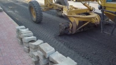 Büyük kazıcı kahve makinesi, katran dökmeden önce yoldaki siyah çakılları bile dengeliyor..