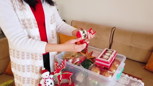 Esmer kadın Noel oyuncaklarını, plastik kutudan topları alıyor.. — Stok video