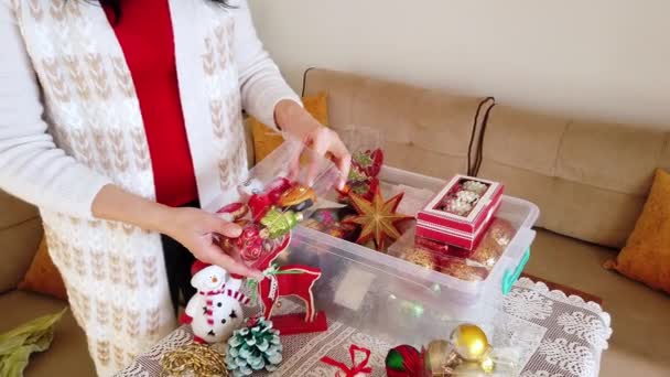 Esmer kadın Noel oyuncaklarını, plastik kutudan topları alıyor.. — Stok video