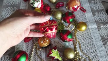 Cam, plastik, Noel ağacı süslemeleri beyaz masa örtüsü. Kadın eli.