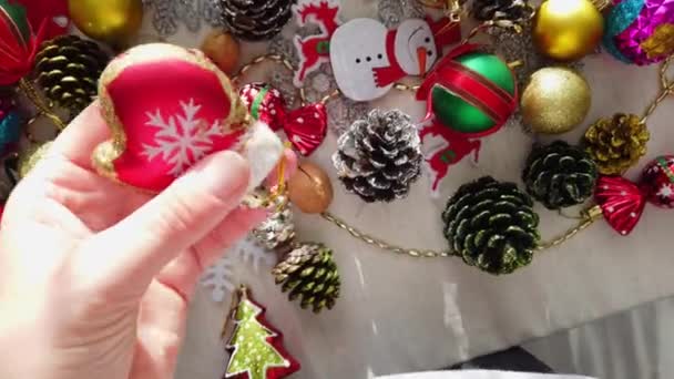 Γυαλί, πλαστικό, χριστουγεννιάτικο δέντρο διακοσμήσεις στο τραπέζι. Γυναικεία χέρια. Κοντινό πλάνο — Αρχείο Βίντεο