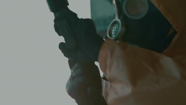 Людина в захисному костюмі, газова маска заряджає гвинтівку, крупним планом. Наслідки пандемії — стокове відео