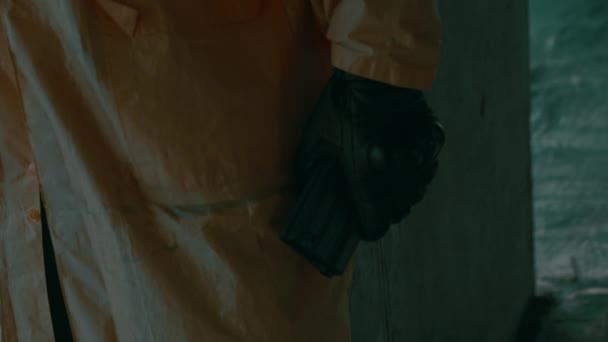 Muž v ochranném obleku, plynová maska nabitá puškou, zblízka. Důsledky pandemie — Stock video